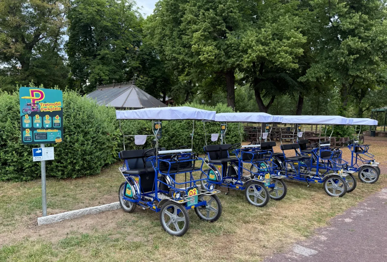 Drei blaue Tretmobile stehen an einer Station